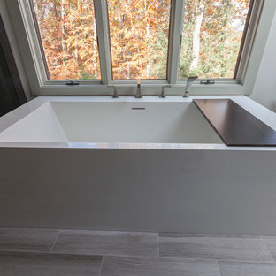 Bild på ett stort funkis en-suite badrum, med släta luckor, bruna skåp, ett fristående badkar, en hörndusch, en toalettstol med separat cisternkåpa, grå kakel, porslinskakel, grå väggar, travertin golv, ett undermonterad handfat, bänkskiva i återvunnet glas, grått golv och dusch med gångjärnsdörr