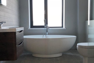 Modernes Badezimmer mit freistehender Badewanne und Wandtoilette in Belfast