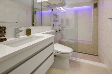 Modelo de cuarto de baño principal contemporáneo de tamaño medio con armarios con paneles lisos, puertas de armario blancas, ducha empotrada, baldosas y/o azulejos beige, paredes beige, lavabo bajoencimera, suelo beige y ducha abierta