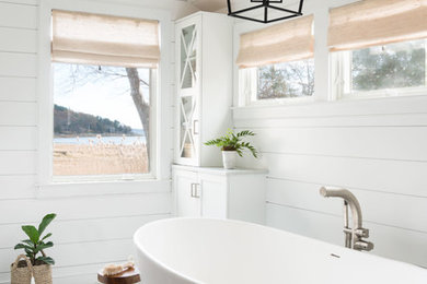 Diseño de cuarto de baño principal de estilo de casa de campo de tamaño medio con armarios estilo shaker, puertas de armario blancas, bañera exenta, paredes blancas, suelo con mosaicos de baldosas y suelo blanco