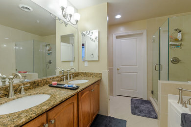 Foto de cuarto de baño principal clásico de tamaño medio con armarios con paneles empotrados, puertas de armario de madera oscura, ducha esquinera, baldosas y/o azulejos blancos, paredes beige y encimera de laminado