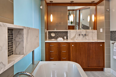 Inspiration for a medium sized contemporary ensuite bathroom in Seattle with flat-panel cabinets, medium wood cabinets, a freestanding bath, an alcove shower, beige tiles, marble flooring, a submerged sink, marble worktops and a hinged door.
