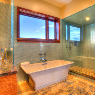 Idee per una stanza da bagno padronale tropicale di medie dimensioni con lavabo da incasso, ante lisce, ante in legno chiaro, top in granito, piastrelle blu, piastrelle in gres porcellanato, pareti blu, pavimento in gres porcellanato, vasca freestanding, doccia alcova e WC monopezzo