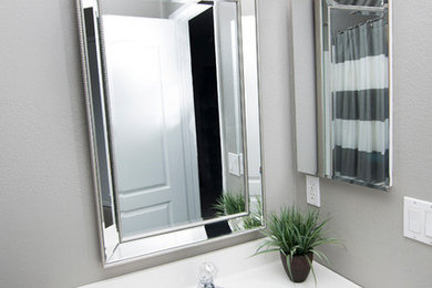 Modelo de cuarto de baño tradicional renovado pequeño con armarios con paneles con relieve, puertas de armario blancas, ducha empotrada, paredes grises, aseo y ducha, lavabo encastrado y encimera de cuarzo compacto