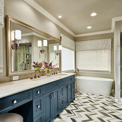 Freestanding bathtub - mid-sized transitional master black and white tile, gray tile and mosaic tile linoleum floor freestanding bathtub idea in Dallas with recessed-panel cabinets, blue cabinets, beige walls, an undermount sink, a two-piece toilet, granite countertops and beige countertops
