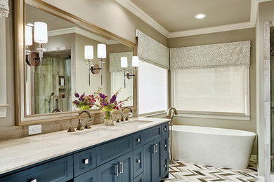 Bild på ett mellanstort vintage en-suite badrum, med skåp i shakerstil, blå skåp, ett fristående badkar, beige väggar, ett undermonterad handfat, bänkskiva i kalksten, klinkergolv i porslin och flerfärgat golv