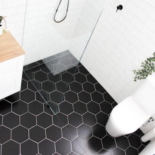 Bathroom - small modern kids' white tile and ceramic tile porcelain tile, black floor, single-sink and brick wall bathroom idea in Perth with shaker cabinets, white cabinets, a one-piece toilet, white walls, a vessel sink, wood countertops, beige countertops and a floating vanity