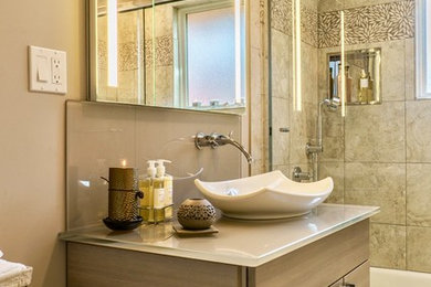Bathroom - small contemporary beige tile ceramic tile and gray floor bathroom idea in Seattle with flat-panel cabinets, beige cabinets, a two-piece toilet, beige walls, a vessel sink and glass countertops