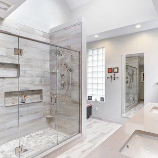 Inspiration for a mid-sized modern master gray tile and porcelain tile porcelain tile, gray floor, double-sink and tray ceiling double shower remodel in Other with a built-in vanity, gray walls, an undermount sink, quartz countertops, a hinged shower door and beige countertops