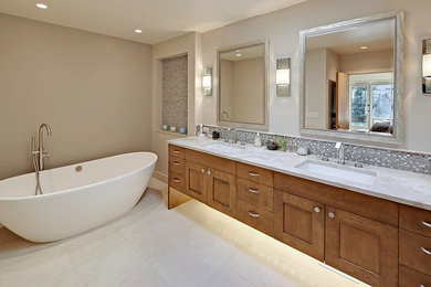 Exempel på ett mellanstort modernt en-suite badrum, med skåp i mellenmörkt trä, ett fristående badkar, grå kakel, vit kakel, keramikplattor, beige väggar, klinkergolv i keramik, ett undermonterad handfat, skåp i shakerstil och bänkskiva i kvartsit