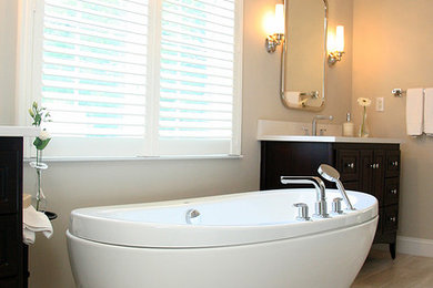 Example of a large transitional master porcelain tile and brown floor freestanding bathtub design in Boston with raised-panel cabinets, dark wood cabinets, brown walls, an undermount sink and quartz countertops