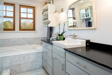 Example of a cottage master stone tile mosaic tile floor bathroom design in San Francisco with gray cabinets and granite countertops