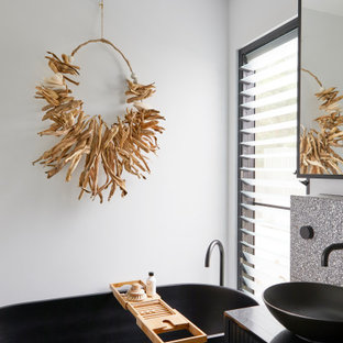 Design ideas for a small contemporary master bathroom in Other with black cabinets, a freestanding tub, ceramic tile, white walls, concrete floors, a vessel sink, solid surface benchtops, white benchtops, a single vanity, a floating vanity, gray tile and grey floor.