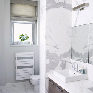 Idee per una stanza da bagno moderna con lavabo a bacinella, ante lisce, ante in legno bruno, piastrelle bianche e piastrelle di marmo