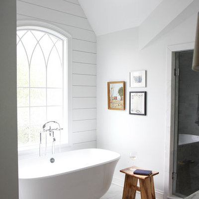 Farmhouse master marble floor freestanding bathtub photo in Chicago with white walls and marble countertops
