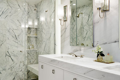 Immagine di una stanza da bagno padronale chic con ante a filo, ante bianche, piastrelle di marmo, pavimento in marmo, lavabo sottopiano, top in marmo e porta doccia a battente