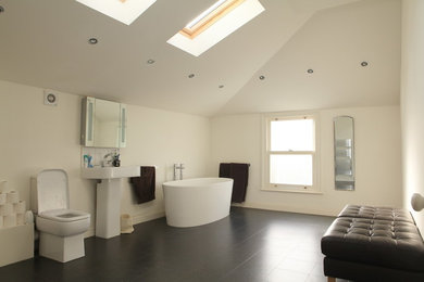 This is an example of a large contemporary family bathroom in London with glass-front cabinets and white cabinets.