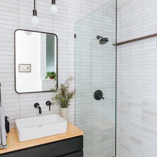 Immagine di una stanza da bagno con doccia nordica con ante lisce, ante nere, doccia alcova, piastrelle bianche, pareti bianche, lavabo a bacinella, top in legno, pavimento multicolore e doccia aperta