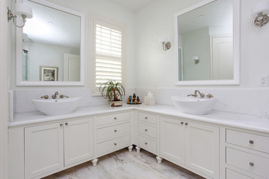 Transitional master white tile marble floor walk-in shower photo in Tampa with white cabinets, white walls, a vessel sink, marble countertops and furniture-like cabinets