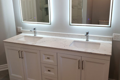 Bathroom - mid-sized contemporary 3/4 white tile and porcelain tile porcelain tile, gray floor and double-sink bathroom idea in Toronto with recessed-panel cabinets, white cabinets, a two-piece toilet, gray walls, an undermount sink, quartz countertops, white countertops and a freestanding vanity