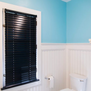 Cette image montre une grand salle de bain principale style shabby chic avec un placard à porte shaker, des portes de placard noires, une baignoire en alcôve, un combiné douche/baignoire, un carrelage noir et blanc, des carreaux de porcelaine, un mur bleu, un sol en carrelage de porcelaine, un lavabo intégré et un plan de toilette en quartz modifié.