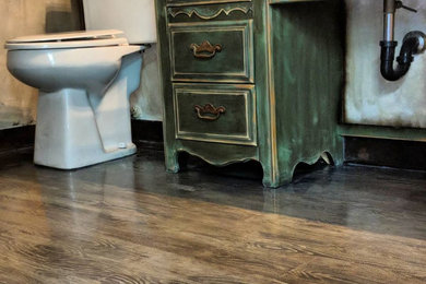 Diseño de cuarto de baño principal rústico con puertas de armario verdes, baldosas y/o azulejos multicolor, suelo de madera pintada, lavabo suspendido, encimera de madera, suelo multicolor y encimeras multicolor
