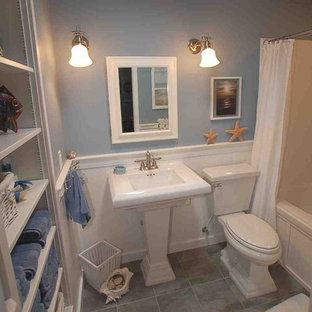 Photo of a small traditional 3/4 bathroom in Boise with a pedestal sink, open cabinets, an alcove tub, a shower/bathtub combo, a two-piece toilet, blue walls and linoleum floors.