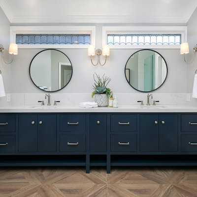Inspiration for a coastal master brown floor bathroom remodel in Orange County with furniture-like cabinets, blue cabinets, gray walls, an undermount sink and white countertops