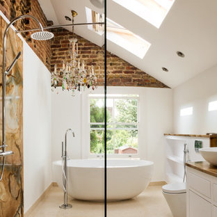 Design ideas for an eclectic bathroom in Tampa with a freestanding tub, a vessel sink, brown tile and stone slab.