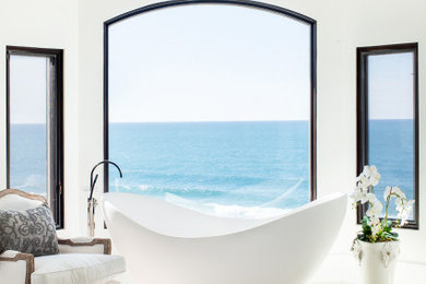 ロサンゼルスにあるラグジュアリーな広い地中海スタイルのおしゃれなマスターバスルーム (置き型浴槽、白い壁、ライムストーンの床、ベージュの床) の写真