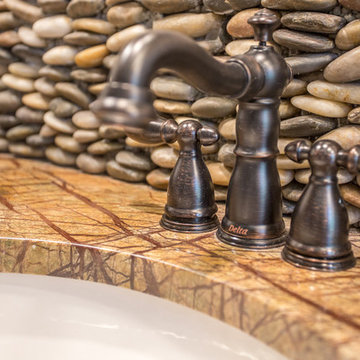 Oiled bronze Delta faucet, granite countertop and stacked pebble backsplash