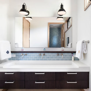 Inspiration for a large transitional 3/4 blue tile and subway tile porcelain tile bathroom remodel in San Francisco with flat-panel cabinets, dark wood cabinets, white walls, a trough sink, solid surface countertops and a one-piece toilet