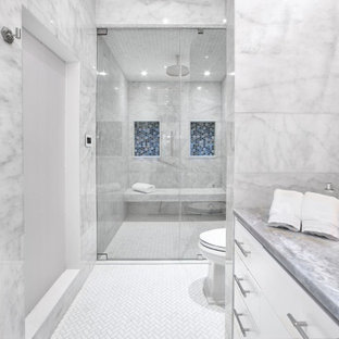 Inspiration för ett mycket stort tropiskt blå blått en-suite badrum, med släta luckor, blå skåp, ett fristående badkar, en toalettstol med hel cisternkåpa, vit kakel, marmorkakel, vita väggar, marmorgolv, ett nedsänkt handfat, marmorbänkskiva, vitt golv och dusch med gångjärnsdörr