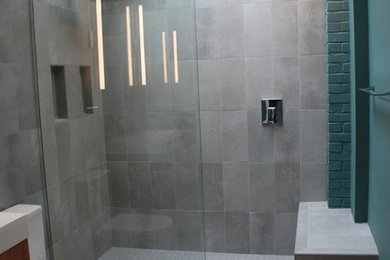 Inspiration for a small contemporary 3/4 gray tile and porcelain tile porcelain tile alcove shower remodel in DC Metro with flat-panel cabinets, medium tone wood cabinets, a two-piece toilet, blue walls and a vessel sink