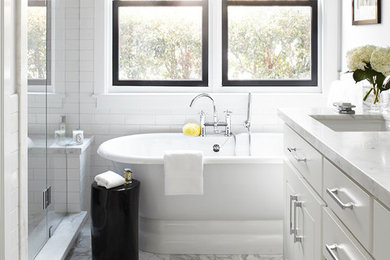 Large elegant master white tile marble floor freestanding bathtub photo in San Francisco with an undermount sink, white cabinets, marble countertops, white walls and flat-panel cabinets