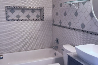 Small eclectic kids' white tile and mosaic tile mosaic tile floor and white floor bathroom photo in Tampa with glass-front cabinets, gray cabinets, a two-piece toilet, gray walls, a vessel sink and granite countertops