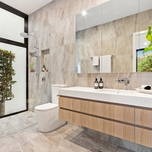Design ideas for a contemporary master bathroom in Melbourne with flat-panel cabinets, light wood cabinets, a curbless shower, a two-piece toilet, beige tile, beige walls, an undermount sink, beige floor, an open shower, white benchtops, a niche and a floating vanity.