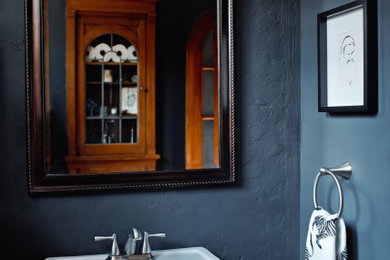 Imagen de cuarto de baño único y de pie minimalista pequeño con puertas de armario blancas, sanitario de dos piezas, paredes azules, suelo de madera en tonos medios, lavabo con pedestal y suelo marrón