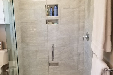 Inspiration for a mid-sized timeless master gray tile beige floor corner shower remodel in Omaha with raised-panel cabinets, white cabinets, beige walls, an undermount sink and a hinged shower door