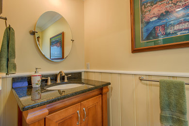 Klassisk inredning av ett litet badrum, med möbel-liknande, skåp i ljust trä, beige väggar och ett undermonterad handfat