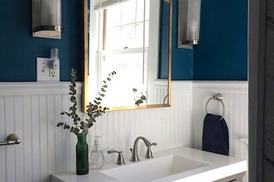 Esempio di una stanza da bagno minimal con consolle stile comò, ante grigie, pareti blu, lavabo integrato, top in quarzo composito e top bianco