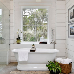 Inspiration for a rustic master gray floor, vaulted ceiling and shiplap wall freestanding bathtub remodel in Austin with white walls