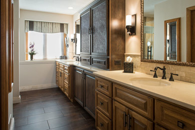 Example of a transitional laminate floor bathroom design in Other with raised-panel cabinets, dark wood cabinets, solid surface countertops and a hinged shower door
