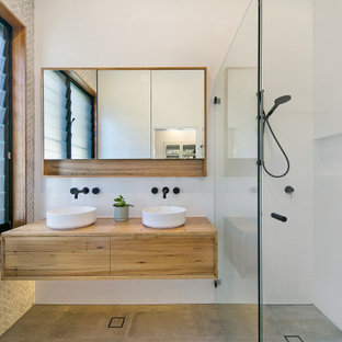 Inspiration for a large contemporary master bathroom in Sydney with ceramic floors, wood benchtops, an open shower, a double vanity, a floating vanity, flat-panel cabinets, medium wood cabinets, a curbless shower, white tile, a vessel sink, grey floor, brown benchtops and a niche.