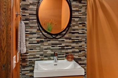 Example of a small minimalist multicolored tile and mosaic tile porcelain tile bathroom design in Minneapolis with a wall-mount sink, flat-panel cabinets, medium tone wood cabinets, a two-piece toilet and orange walls