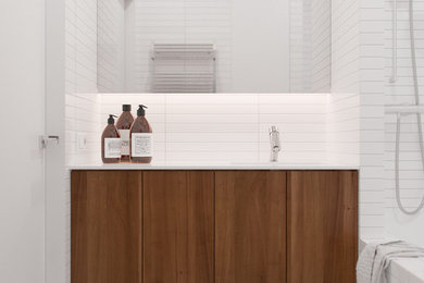 Réalisation d'une salle de bain design avec un lavabo intégré, une baignoire posée, un carrelage blanc, des carreaux de céramique, un mur blanc et un sol en carrelage de céramique.