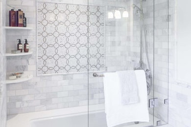Foto på ett mellanstort vintage en-suite badrum, med luckor med upphöjd panel, grå skåp, en dusch/badkar-kombination, en toalettstol med hel cisternkåpa, grå kakel, vit kakel, porslinskakel, grå väggar, klinkergolv i porslin, ett undermonterad handfat, marmorbänkskiva, ett badkar i en alkov och grått golv