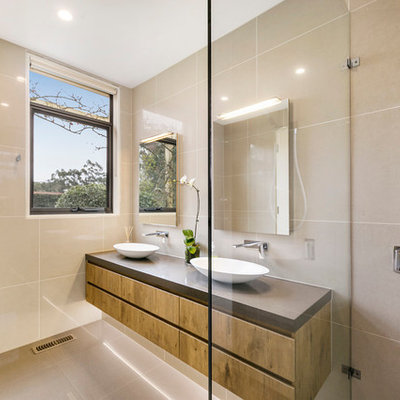 Bathroom - contemporary beige tile and porcelain tile porcelain tile and beige floor bathroom idea in Melbourne with furniture-like cabinets, medium tone wood cabinets, a wall-mount toilet, beige walls, a vessel sink, quartz countertops and brown countertops