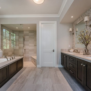Imagen de cuarto de baño principal, campestre, grande, con armarios estilo shaker, puertas de armario de madera en tonos medios, bañera encastrada sin remate, ducha a ras de suelo, baldosas y/o azulejos grises, paredes grises, lavabo bajoencimera, suelo gris, ducha abierta, sanitario de una pieza, baldosas y/o azulejos de cerámica, encimera de cuarzo compacto y suelo de baldosas de porcelana