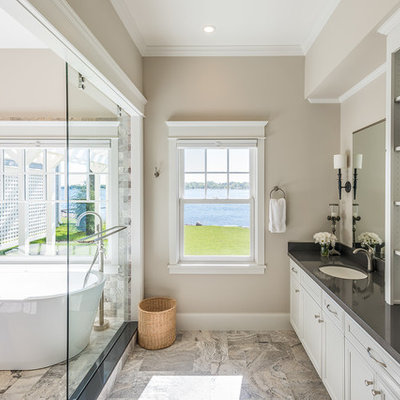 Large elegant master multicolored tile and stone tile porcelain tile bathroom photo in Minneapolis with flat-panel cabinets, white cabinets, an undermount sink, beige walls, solid surface countertops and gray countertops